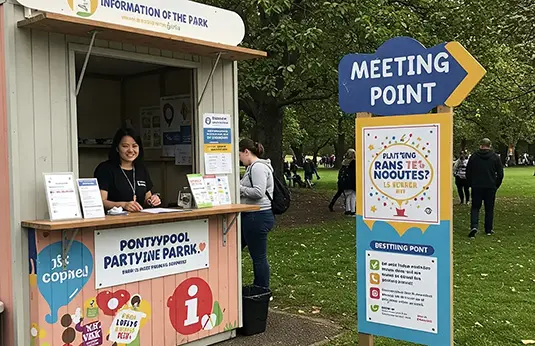 A scene showing an information hut and Meeting Point sign