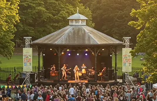 A scene showing a band playing on a stage to a crowd