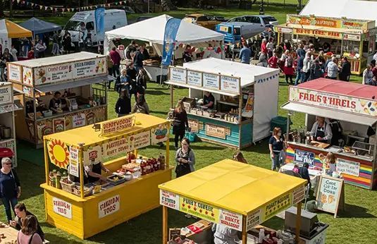 A scene showing a selection of food and drinks stands
